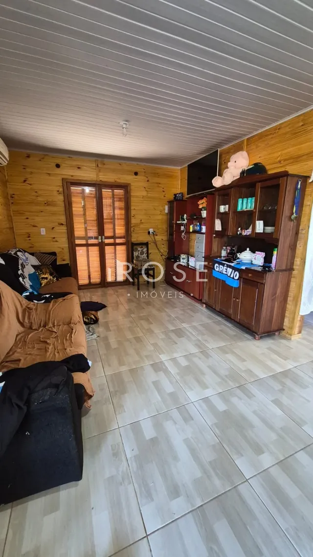 Quarto com paredes de madeira e piso cerâmico em uma residência.