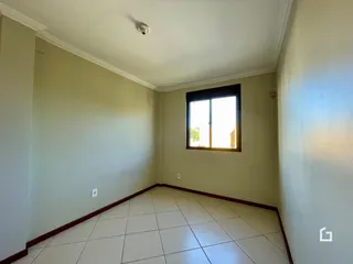 Vista de um corredor interno com piso de cerâmica clara.