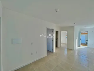 Hall de entrada com piso de cerâmica e paredes brancas.