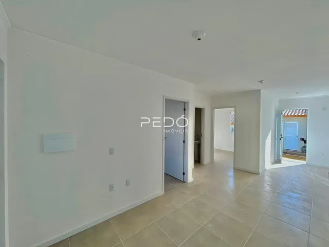 Hall de entrada com piso de cerâmica e paredes brancas.