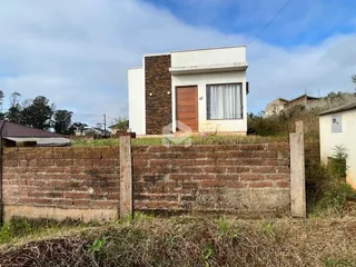 Fachada de uma casa em Lajeado, Brasil, com muro de tijolos no primeiro plano.