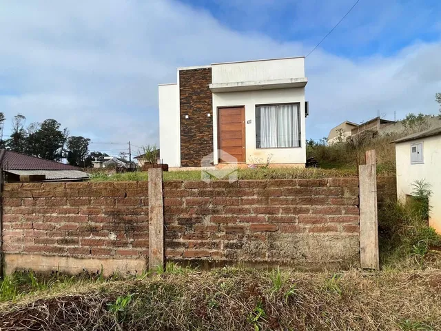 Fachada de uma casa em Lajeado, Brasil, com muro de tijolos no primeiro plano.