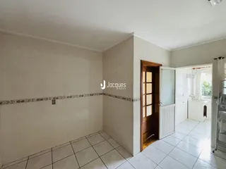 Interior de uma área com piso cerâmico e parede clara.