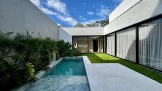 Vista da fachada moderna de uma residência com piscina e jardim.