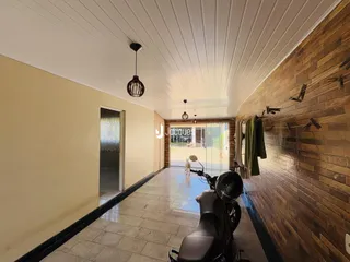 Hall de entrada com paredes de tijolo e piso de cerâmica.