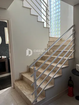 Foto de uma escadaria interna com corrimão branco.