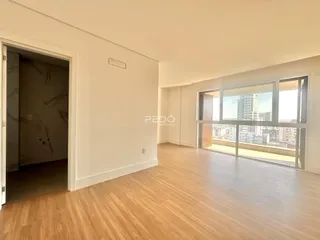 Sala de estar com piso de madeira e vista da cidade.