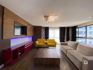 Sala de estar com piso de madeira e móveis de destaque.