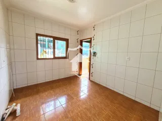 Vista interna de uma sala com piso de cerâmica e paredes brancas.