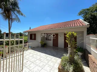 Fachada de uma casa em Lajeado, Brasil, com um pátio frontal e cerca branca.
