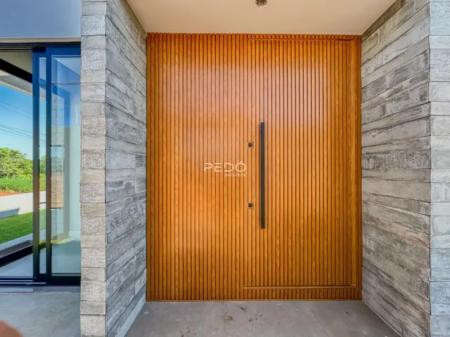 Parede de fachada com porta de madeira vertical em um imóvel.