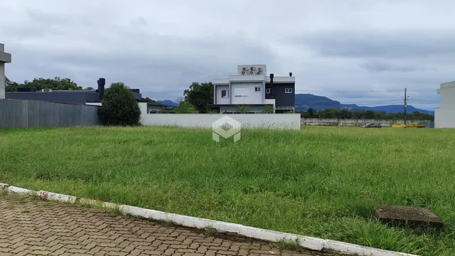 Vista externa de uma casa com um grande gramado ao fundo.
