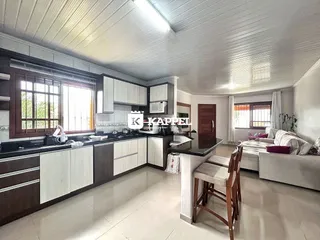 Foto de uma sala de estar e cozinha com armários brancos e piso claro.