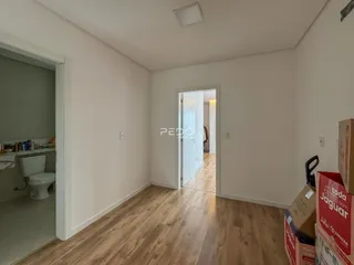 Interior de um corredor com piso de madeira clara.