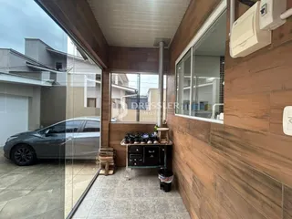 Vista interna de um imóvel com paredes de madeira e piso de cerâmica.