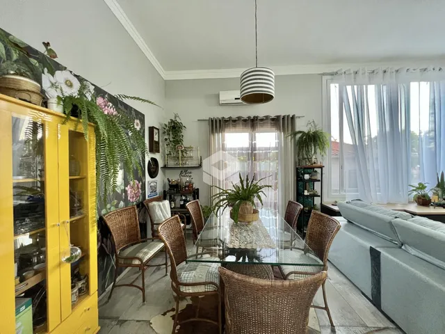 Sala de jantar com mesa de vidro e cadeiras de vime.