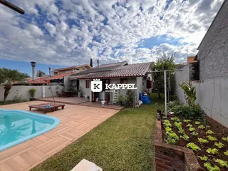 Foto da fachada de uma residência com piscina e jardim em Lajeado.