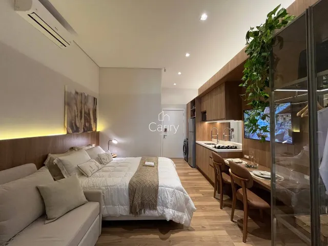 Quarto com cama grande e decoração moderna em ambiente com cozinha integrada.
