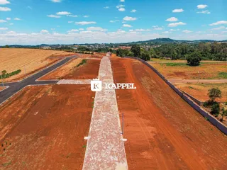Vista aérea de um terreno aberto com campo seco e estrada no interior de Lajeado.