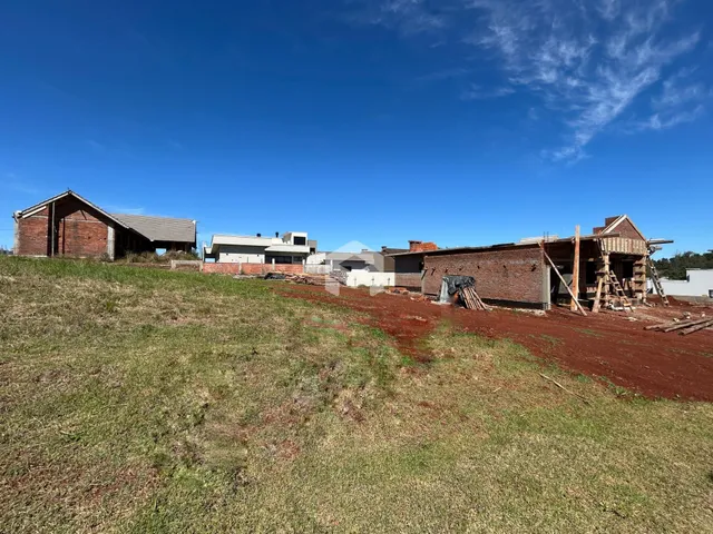 Vista externa de propriedades rurais com construções de madeira e vegetação seca.