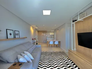 Interior de uma sala de estar com sofá e decoração de madeira.