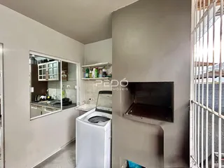 Interior de uma cozinha com armários brancos e máquina de lavar roupa.
