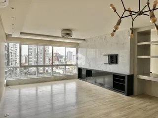 Sala de estar com grandes janelas oferecendo vista da cidade.