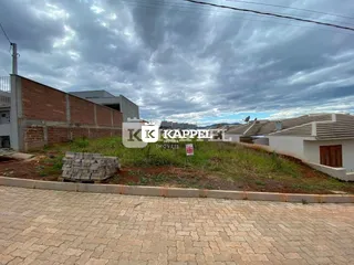 Fachada de uma construção em Lajeado, Brasil, mostrando um muro de tijolos e área externa.