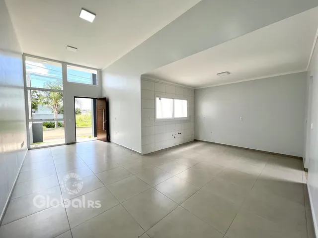 Ambiente interno amplo com piso de cerâmica e grandes portas de vidro.