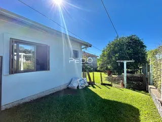 fachada de casa branca com quintal gramado e cerca de madeira