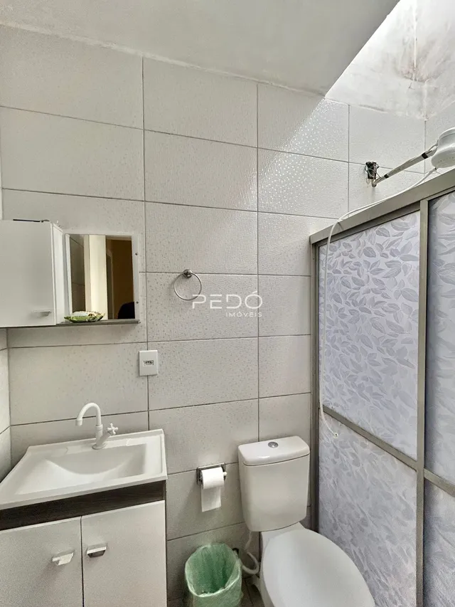 Foto de um banheiro interno com louças sanitárias brancas.