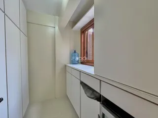 Hall de entrada com revestimento branco e piso claro.