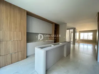 Cozinha moderna com armários de madeira clara e piso de cerâmica.