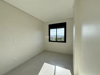 Interior de um ambiente com paredes brancas e piso de cerâmica.