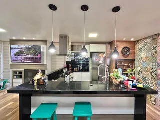 Vista da cozinha moderna com ilha e armários em Lajeado.