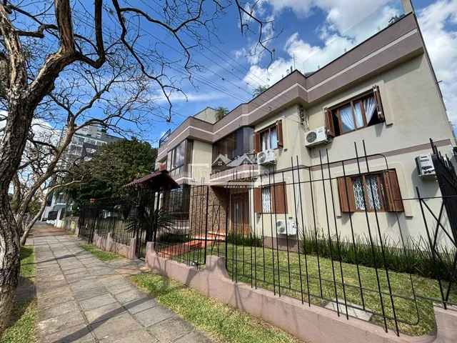 Fachada de uma residência em Lajeado, Brasil, com cerca e jardim na frente.