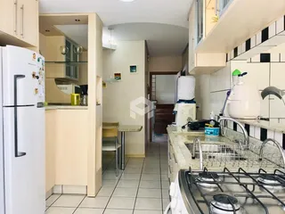 Vista interna de uma cozinha com armários brancos e piso cerâmico.