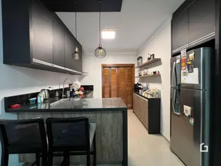 Foto de uma cozinha moderna com armários escuros e bancada de granito.