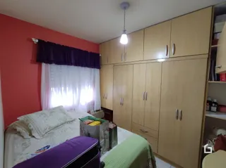 Quarto com cama e armários de madeira em Lajeado.