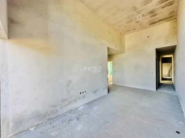 Corredor interno de um imóvel com paredes de concreto aparente.