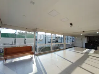 Sala de estar com grandes janelas e um banco de madeira.