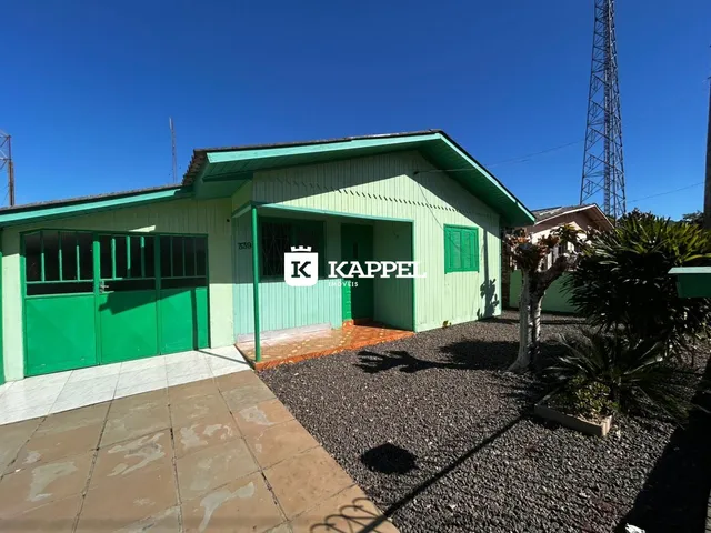Fachada externa de uma casa verde com garagem e área externa em Lajeado, Brasil.