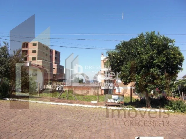 Fachada de uma propriedade com área externa pavimentada e vegetação.