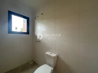 Foto da parede de um banheiro com uma janela.