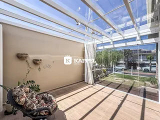 Sala de estar com teto de vidro e vista para o jardim externo.