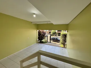 Interior de um ambiente com piso de cerâmica e vista para o quintal.