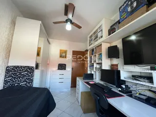 Quarto com armário e área de trabalho em apartamento.