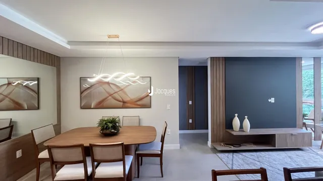 Vista de uma sala de jantar com mesa de madeira e decoração moderna.