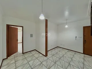 Interior de um corredor com piso de cerâmica e portas de madeira.
