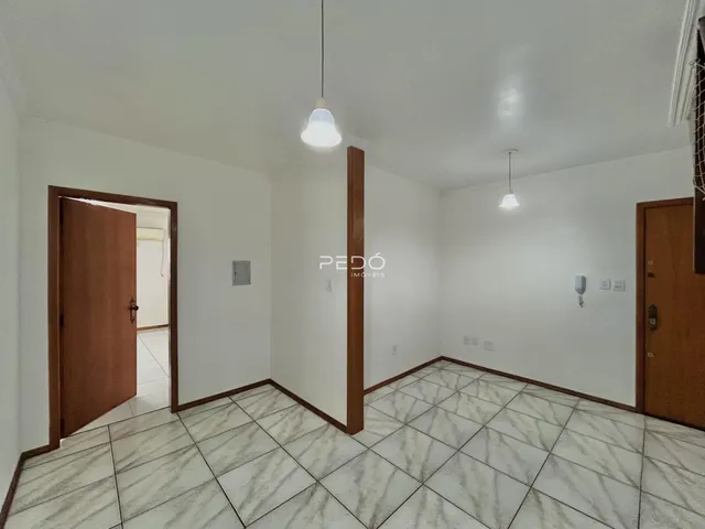 Interior de um corredor com piso de cerâmica e portas de madeira.